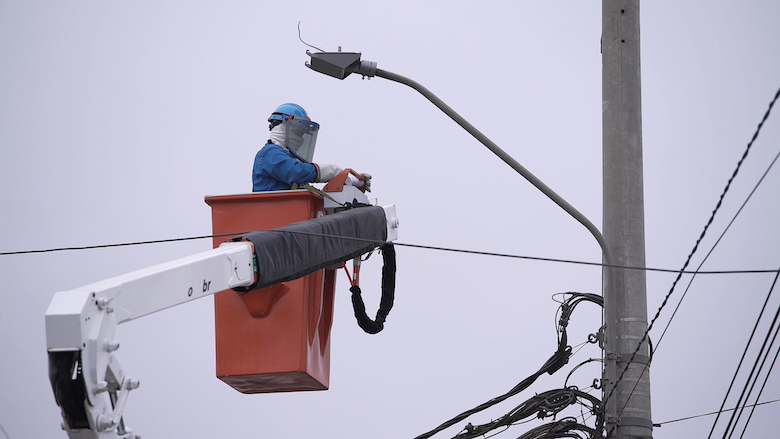 persona trabajando en alturas por poste electrico